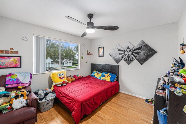 bedroom with baseboards, ceiling fan, and wood finished floors