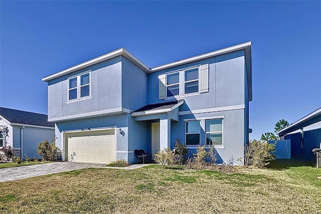 view of front of house with stucco siding, driveway, a front lawn, and a garage