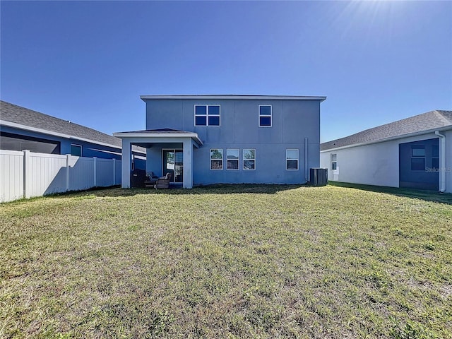 rear view of property featuring central air condition unit, a lawn, stucco siding, and fence