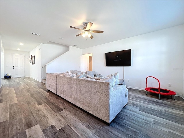 living area featuring baseboards, wood finished floors, visible vents, and ceiling fan