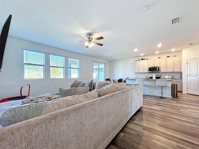 living area with visible vents, recessed lighting, ceiling fan, and wood finished floors