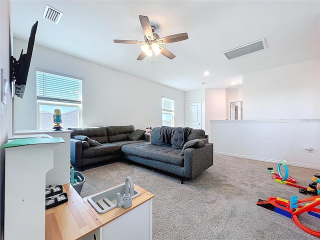 living room featuring carpet flooring, a ceiling fan, visible vents, and baseboards