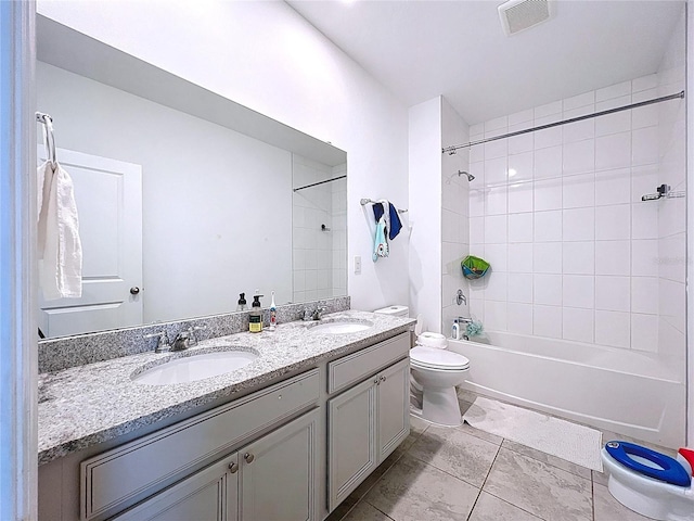 bathroom featuring double vanity, visible vents, toilet, and a sink