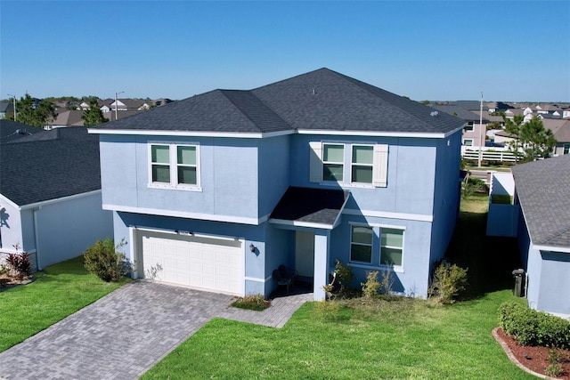 traditional-style house featuring stucco siding, an attached garage, a front lawn, and fence