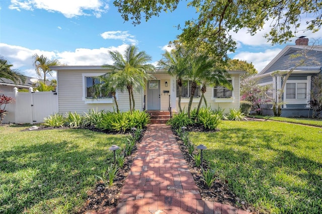 view of front of property featuring fence, a front yard, and a gate