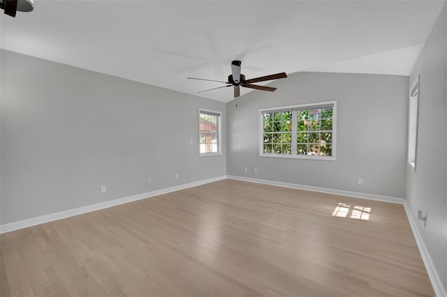 spare room featuring light wood-style flooring, baseboards, a ceiling fan, and vaulted ceiling