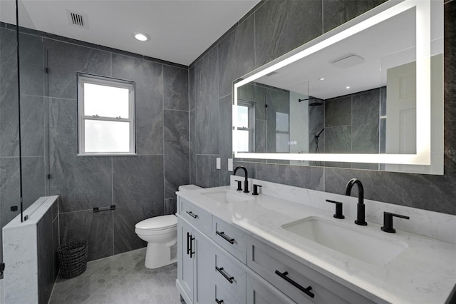 full bathroom with visible vents, tile walls, and a sink