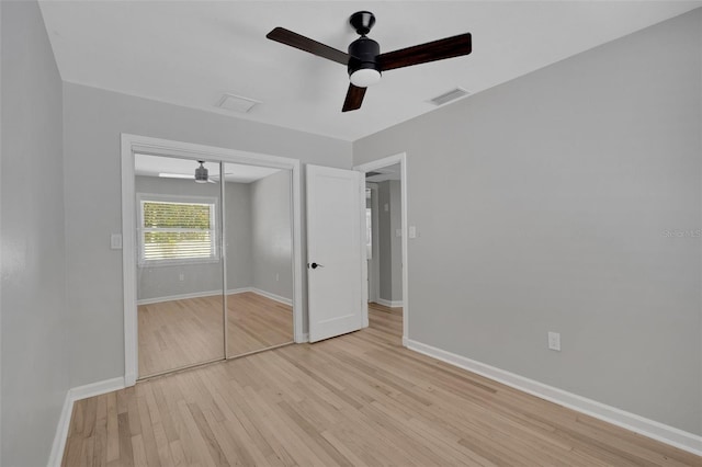 unfurnished bedroom with baseboards, visible vents, light wood finished floors, ceiling fan, and a closet