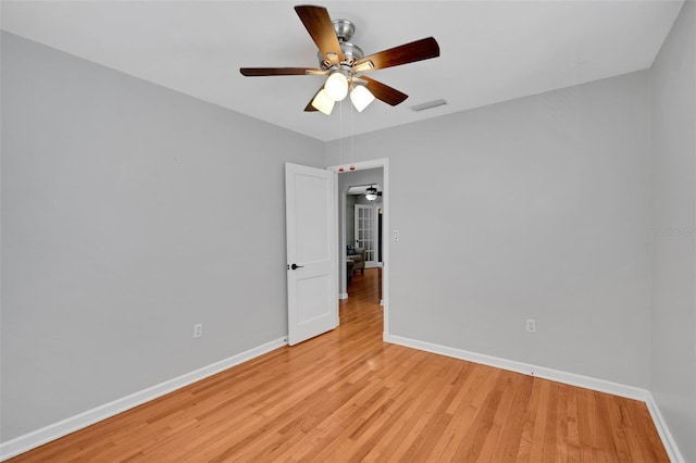 empty room with visible vents, baseboards, ceiling fan, and light wood-style flooring