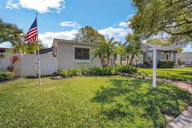 view of front of property featuring fence, a front lawn, and a gate