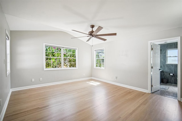 empty room with light wood-style flooring, baseboards, lofted ceiling, and a ceiling fan