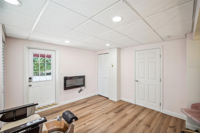 interior space featuring light wood finished floors, recessed lighting, a paneled ceiling, and baseboards