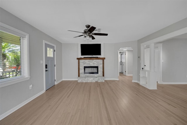 unfurnished living room with a fireplace, baseboards, light wood-type flooring, and ceiling fan
