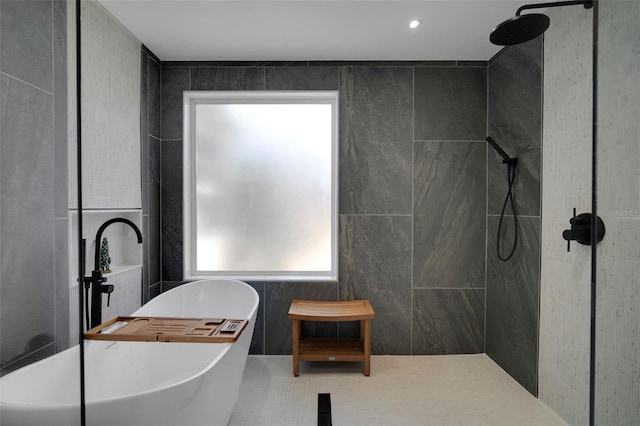 full bath featuring plenty of natural light, tiled shower, tile walls, and a freestanding tub