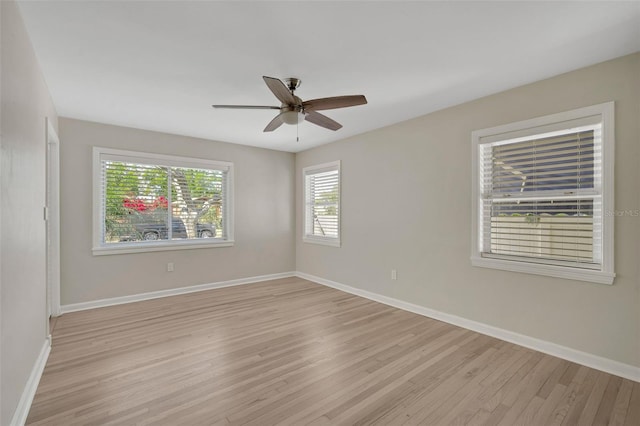 empty room featuring baseboards, ceiling fan, and light wood finished floors