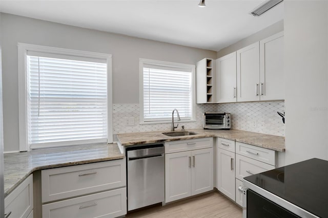 kitchen featuring range with electric cooktop, tasteful backsplash, white cabinets, and a sink