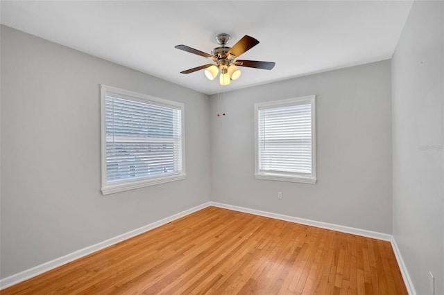spare room featuring light wood-type flooring, baseboards, and ceiling fan