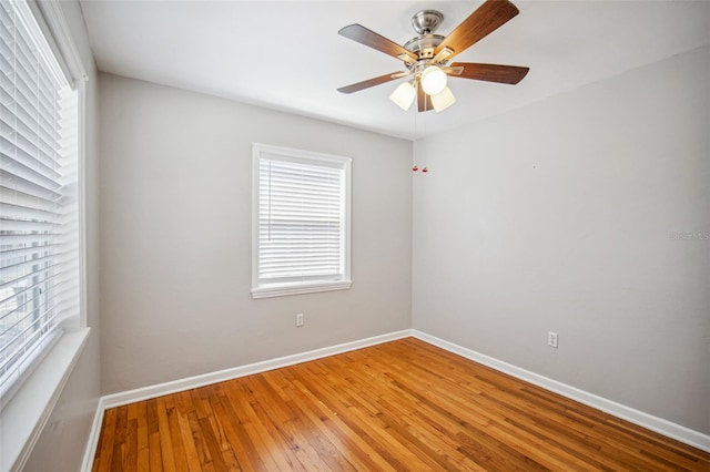 empty room with baseboards, light wood-type flooring, and ceiling fan