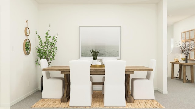 dining space featuring baseboards and carpet