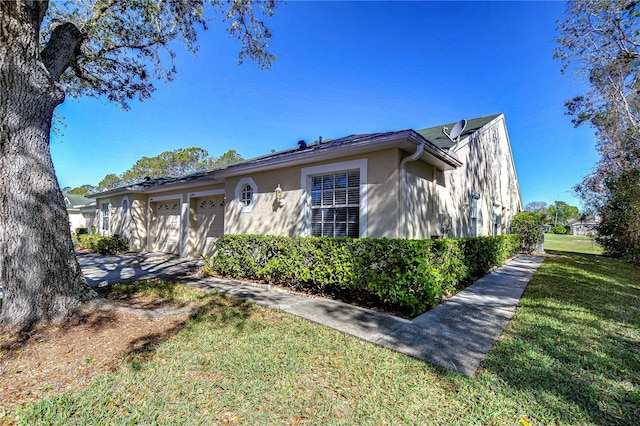 view of front of property with a garage, stucco siding, and a front yard