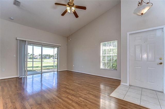 entrance foyer featuring wood finished floors, baseboards, a ceiling fan, visible vents, and high vaulted ceiling