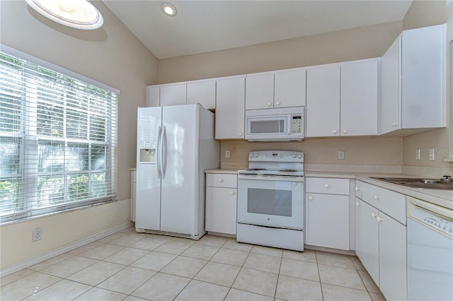 kitchen featuring white appliances, light tile patterned flooring, a sink, light countertops, and white cabinets