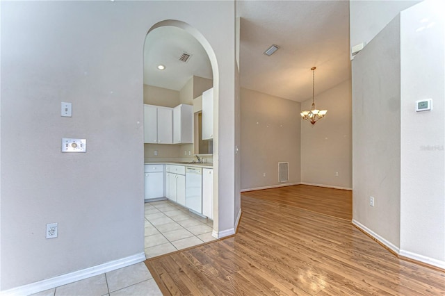 interior space with light wood-type flooring, visible vents, dishwasher, and white cabinetry