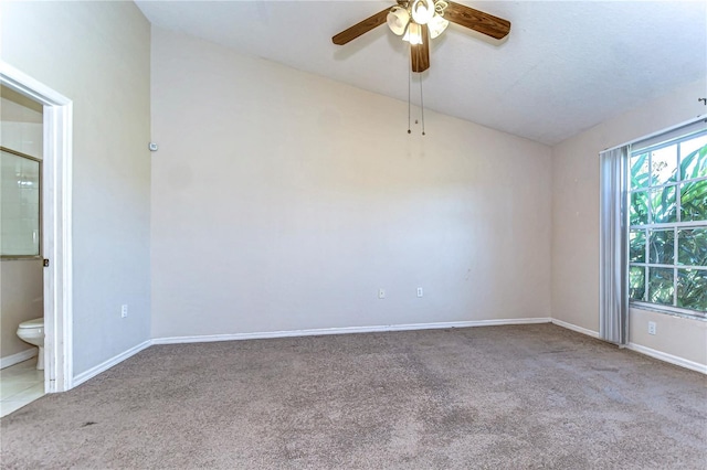 spare room featuring carpet flooring, baseboards, lofted ceiling, and ceiling fan