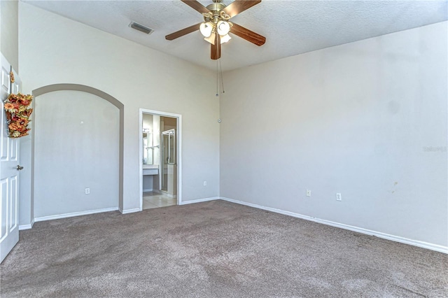 unfurnished bedroom featuring baseboards, carpet flooring, a textured ceiling, and visible vents