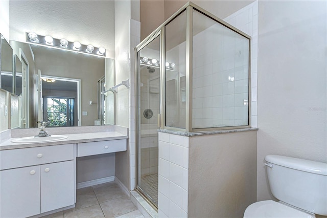 full bathroom featuring vanity, tile patterned floors, toilet, and a stall shower