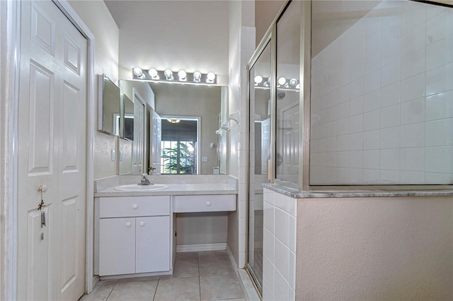 full bath featuring tile patterned flooring, vanity, and tiled shower