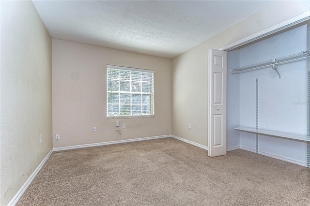 unfurnished bedroom featuring baseboards, carpet floors, and a textured ceiling