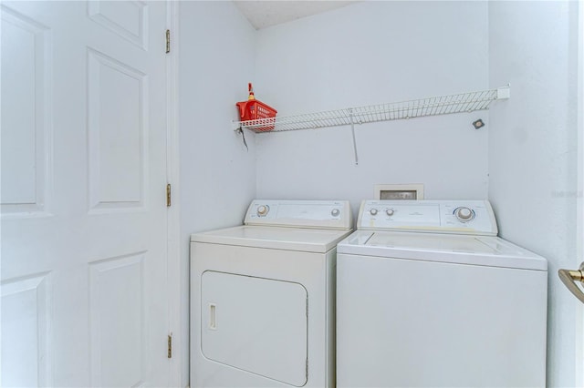 clothes washing area featuring laundry area and washer and clothes dryer