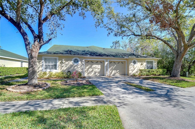 ranch-style house with a garage, concrete driveway, and stucco siding