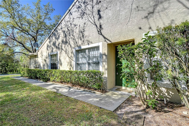 exterior space featuring a lawn and stucco siding