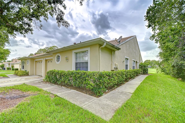 34907 Double Eagle Ct, Zephyrhills, FL 33541 - view of front facade featuring stucco siding, an attached garage, a front lawn, and driveway