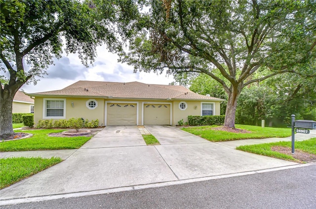 34907 Double Eagle Ct, Zephyrhills, FL 33541 - ranch-style home with a garage, a front yard, stucco siding, driveway, and roof with shingles