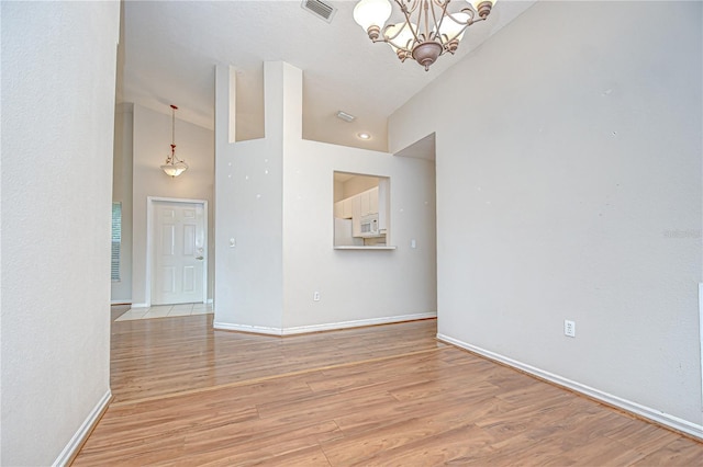 34907 Double Eagle Ct, Zephyrhills, FL 33541 - spare room featuring a chandelier, baseboards, light wood finished floors, and high vaulted ceiling
