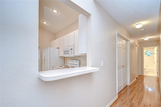 34907 Double Eagle Ct, Zephyrhills, FL 33541 - hallway featuring light wood-style flooring, baseboards, and a textured wall