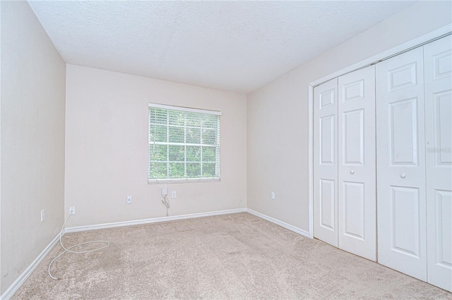 34907 Double Eagle Ct, Zephyrhills, FL 33541 - unfurnished bedroom with carpet floors, a textured ceiling, baseboards, and a closet