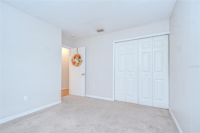 34907 Double Eagle Ct, Zephyrhills, FL 33541 - unfurnished bedroom with carpet flooring, baseboards, a closet, and a textured ceiling
