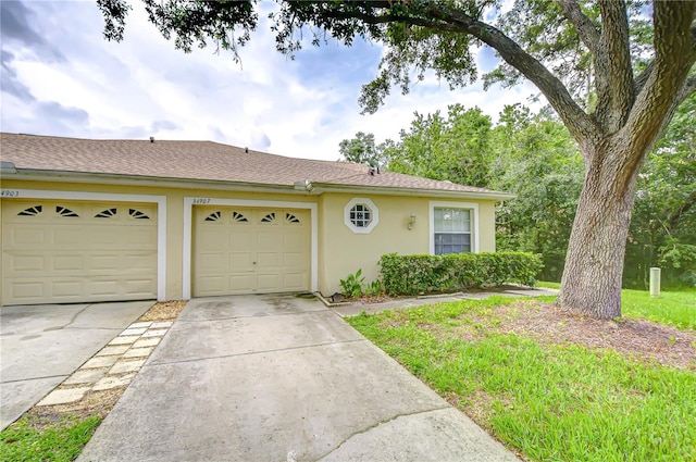 34907 Double Eagle Ct, Zephyrhills, FL 33541 - view of front of home with concrete driveway, stucco siding, an attached garage, and a shingled roof