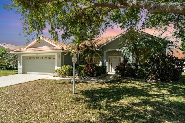 7581 Palmer Glen Cir, Sarasota, FL 34240 - view of front of property with a tile roof, concrete driveway, a garage, a yard, and stucco siding