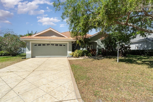 7581 Palmer Glen Cir, Sarasota, FL 34240 - view of front facade featuring stucco siding, a tile roof, driveway, a garage, and a front lawn
