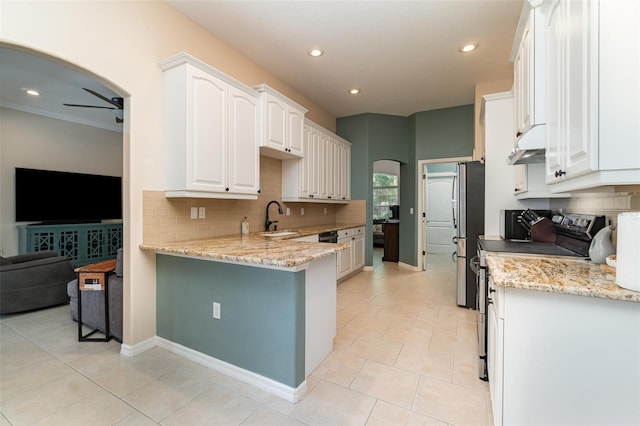 7581 Palmer Glen Cir, Sarasota, FL 34240 - kitchen with a sink, appliances with stainless steel finishes, backsplash, arched walkways, and recessed lighting