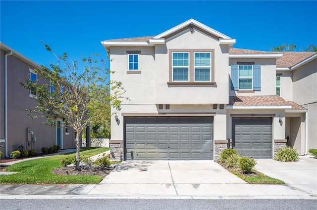 multi unit property with stone siding, stucco siding, driveway, and a garage