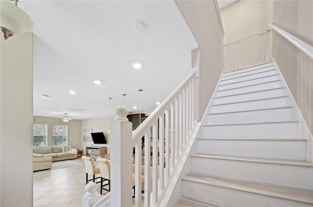 stairs with a ceiling fan, recessed lighting, and tile patterned flooring