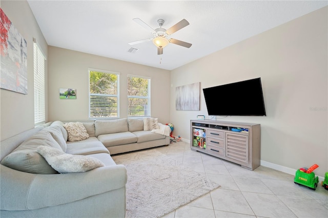 living room with light tile patterned floors, visible vents, baseboards, and a ceiling fan