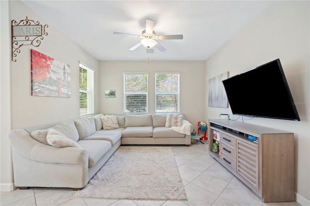 living room with light tile patterned floors, visible vents, and a ceiling fan