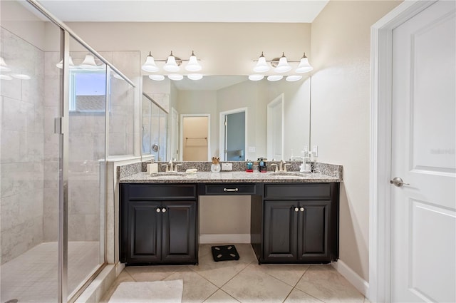 bathroom with double vanity, a shower stall, tile patterned floors, and a sink